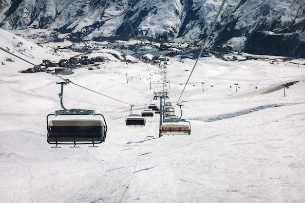 Cabinovia e piste da sci sulla neve al giorno pieno di sole sulla montagna. Montagne del Caucaso, Georgia, regione Gudauri