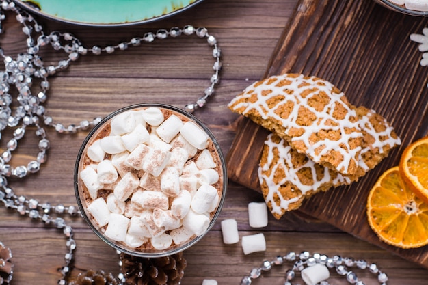 Cacao caldo con marshmallow e cannella in bicchieri sul tavolo con decorazioni natalizie. Vista dall'alto