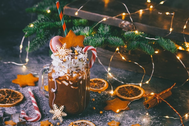 Cacao di Natale con luci scintillanti, biglietto di Capodanno, foto d'atmosfera, bevanda al cioccolato calda su fondo scuro