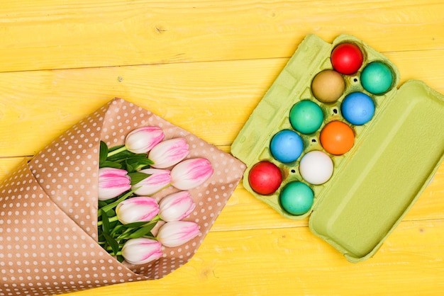 Caccia alle uova Uova dipinte di buona Pasqua nel vassoio delle uova Vacanze primaverili Preparazione della celebrazione delle vacanze Bouquet di fiori di tulipano Vacanze sane e felici Cena di Pasqua