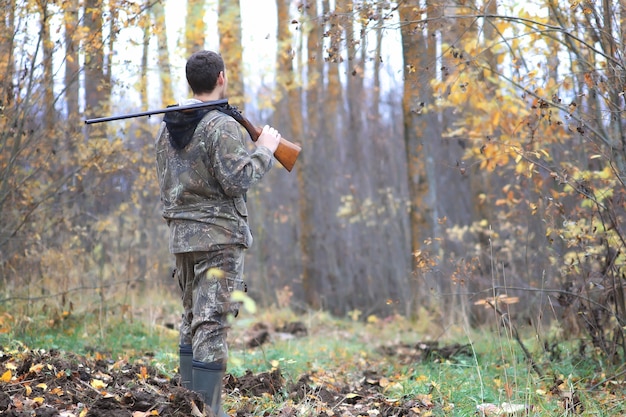 Cacciatore di uomini all'aperto nella foresta autunnale a caccia da solo