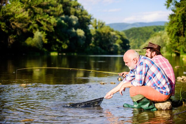 Cacciatori illegali che pescano caviale sul mercato nero Caccia illegale che caccia caviale Estrae uova da sturgeon catturato nel fiume Trappola per pesci Uomini seduti sul fiume con attrezzature da pesca Cacciatore criminale e licenza di pesca