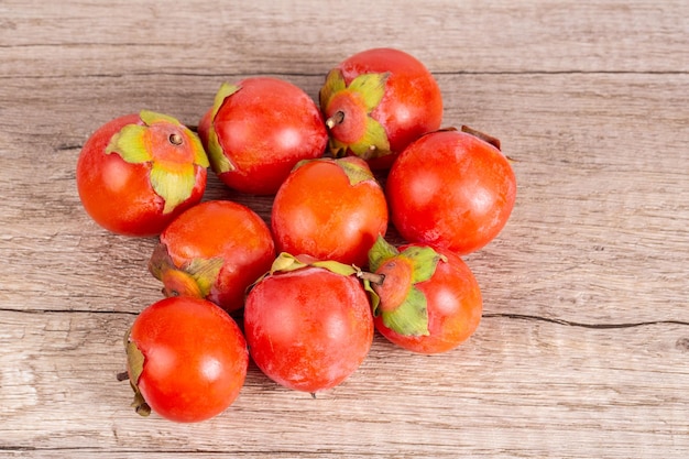 Cachi sulla vista superiore della frutta di autunno del fondo della tavola di legno