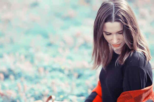 Caduta dei capelli del vento all'aperto / ritratto autunnale ragazza adulta modello donna con i capelli lunghi in una giornata ventosa nel parco