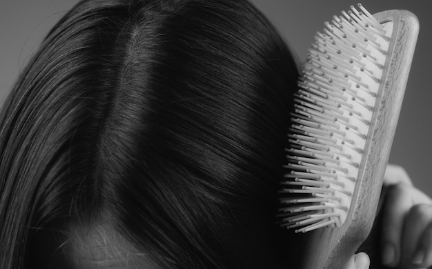 Caduta dei capelli di perdita di capelli del primo piano nel problema di sforzo della spazzola per capelli della donna con un pettine