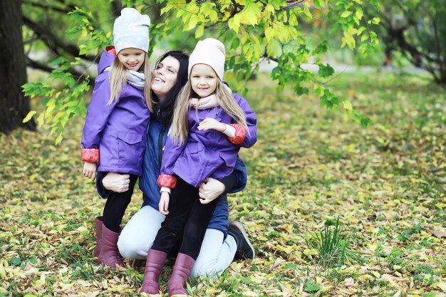 Caduta delle foglie nel parco. Bambini per una passeggiata nel parco autunnale. Famiglia. Autunno. Felicità.