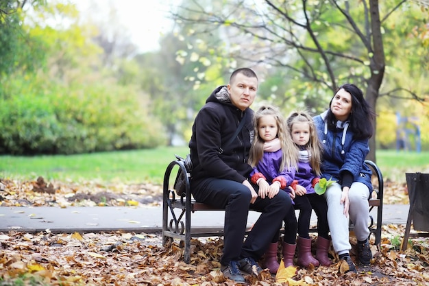 Caduta delle foglie nel parco. Bambini per una passeggiata nel parco autunnale. Famiglia. Autunno. Felicità.