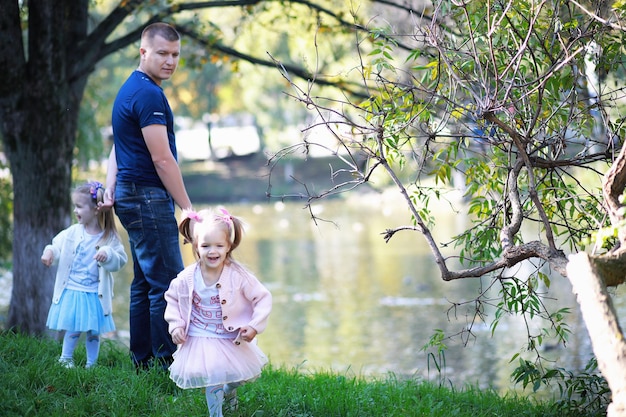 Caduta delle foglie nel parco. Bambini per una passeggiata nel parco autunnale. Famiglia. Autunno. Felicità.