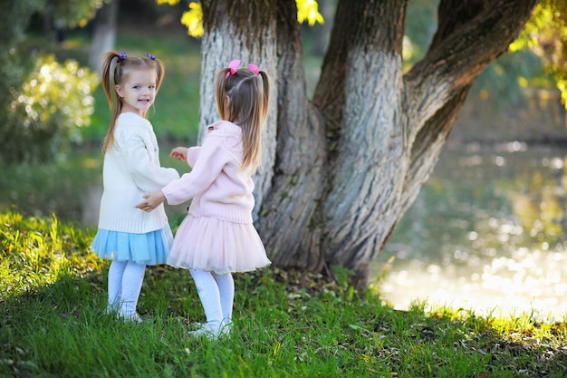 Caduta delle foglie nel parco. Bambini per una passeggiata nel parco autunnale. Famiglia. Autunno. Felicità.