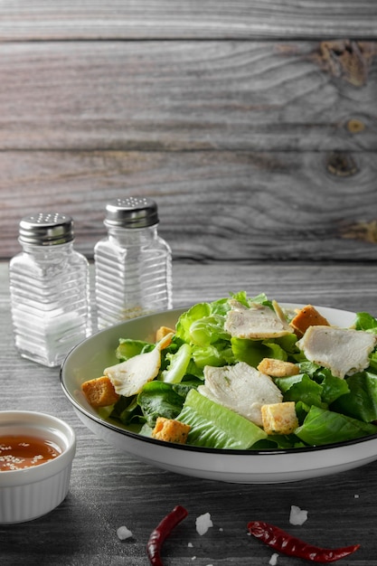 Caesar Salad di verdure verdi e petto di pollo al pepe nero con salsa all'olio di sesamo