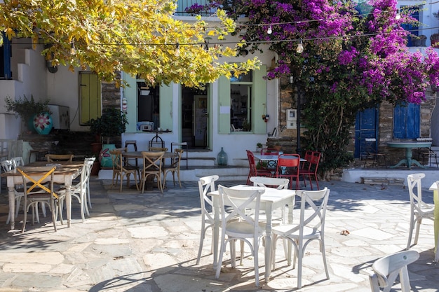 Caffè all'aperto sull'isola di Tinos Villaggio di Dio Horia Cicladi Grecia Sedia da tavolo in legno su cortile pavimentato