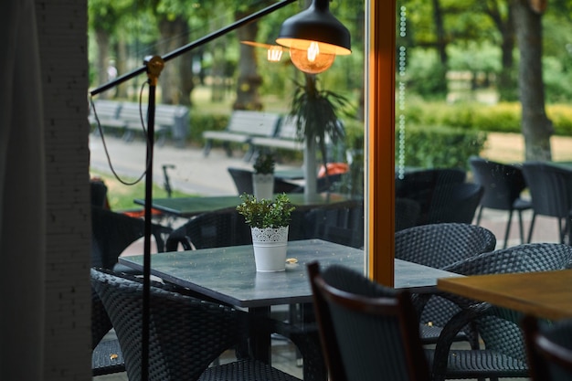 Caffè all'aperto vuoto - eleganti mobili neri su uno sfondo verde del parco. Tavoli e sedie sulla terrazza del ristorante.