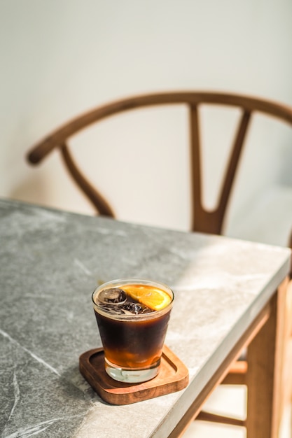 Caffè americano con arancia sul tavolo