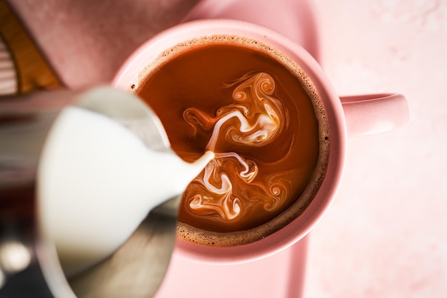 Caffè americano con latte in tazza e piattino isolato su sfondo bianco. Foto di alta qualità