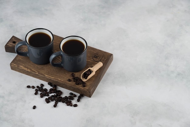Caffè americano sul piatto di legno con i chicchi di caffè