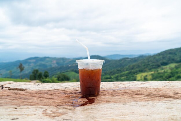 Caffè americano sul tavolo di legno con sfondo Mountain Hill View