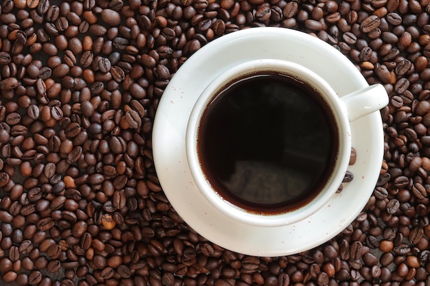 Caffè americano Vista superiore di una tazza di caffè sullo sfondo di chicchi di caffè arrostiti