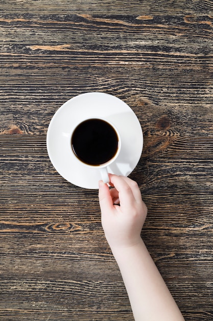 Caffè aromatico in una tazza bianca durante un pasto, caffè caldo in una tazza rotonda, vista dall'alto