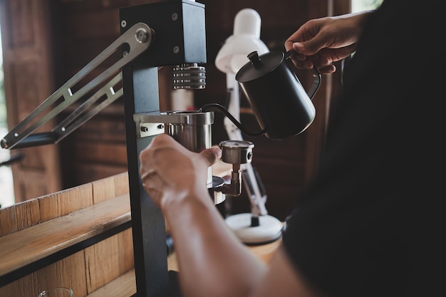 Caffè barista che prepara il caffè con il concetto di servizio di preparazione della macchina per caffè espresso a leva manuale.