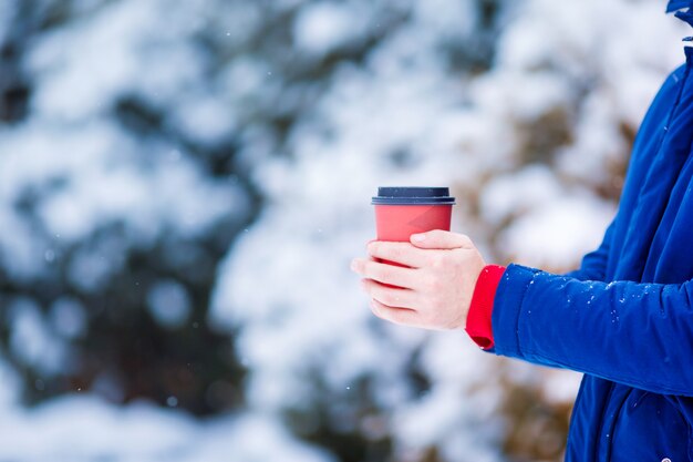 Caffè bevente dell'uomo del primo piano nel giorno di inverno congelato all'aperto