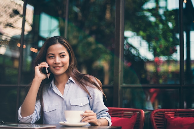 Caffè bevente della donna asiatica nel tono di colore d&#39;annata