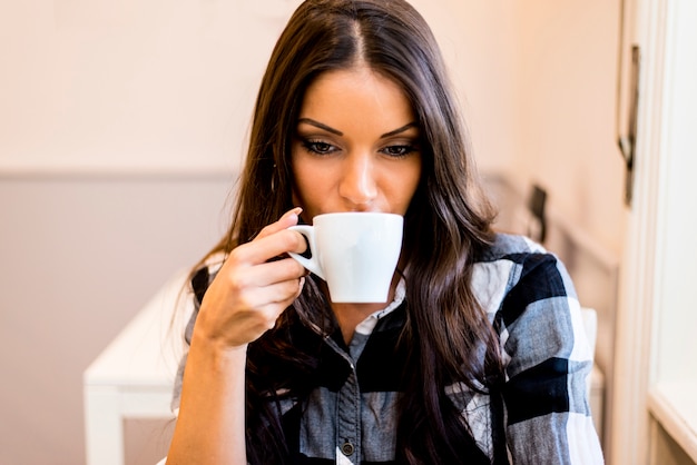 Caffè bevente della giovane donna graziosa Im cafe