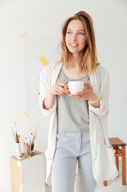 Caffè bevente felice giovane pittore caucasico della signora.