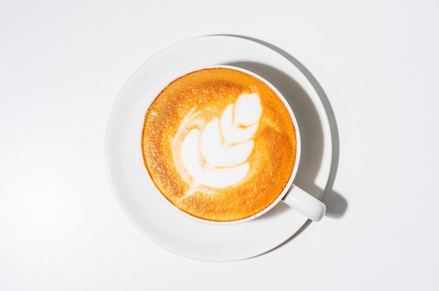 Caffè caldo con Latte art e tazza bianca su sfondo bianco