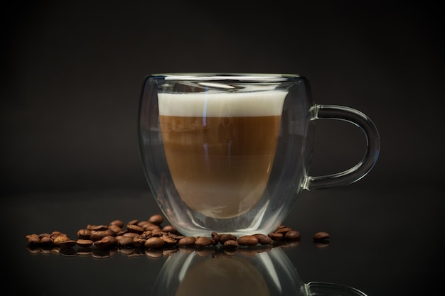 caffè caldo con latte su sfondo nero.