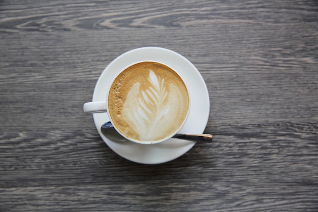 Caffè caldo del latte su fondo di legno