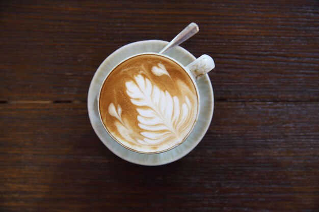 Caffè caldo del latte su fondo di legno