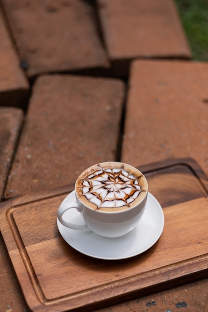 Caffè caldo di arte del latte sulla tavola di legno, tempo di relax