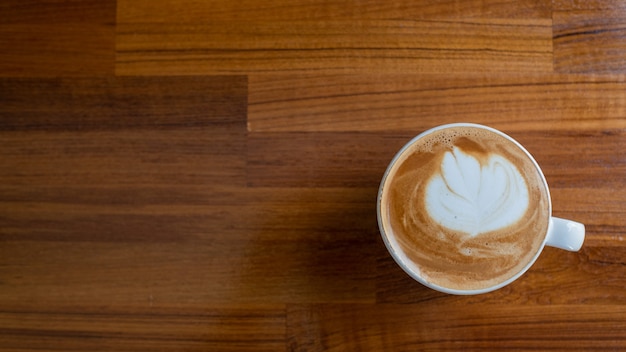 Caffè caldo di arte del latte sulla tavola di legno, tempo di relax