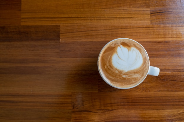 Caffè caldo di arte del latte sulla tavola di legno, tempo di relax