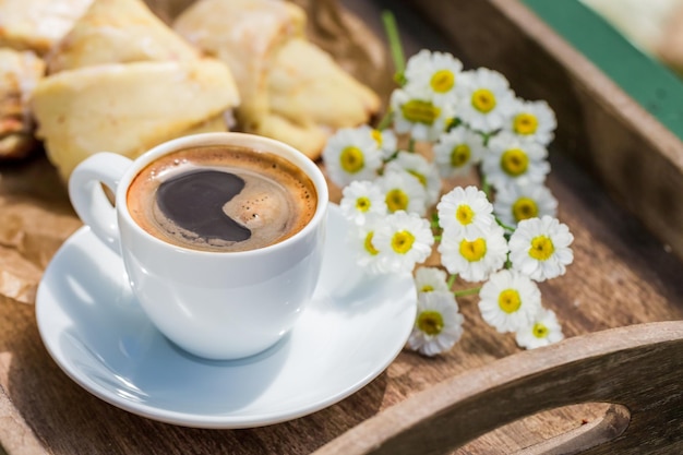 Caffè caldo e delizioso croissant per la colazione in giardino