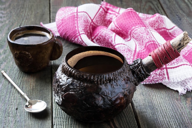 Caffè caldo in stoviglie di argilla su un tavolo di legno. Stile vintage, messa a fuoco selettiva