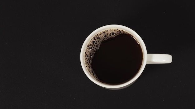 Caffè caldo in tazza bianca isolata su fondo nero bianco. vista dall'alto