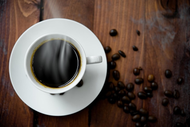 Caffè caldo in tazza bianca su fondo di legno