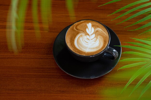 Caffè caldo latte art su tavola di legno relax timexA