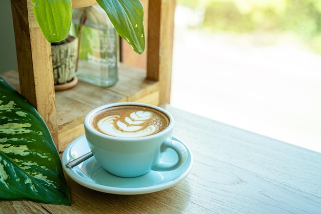 Caffè caldo latte con schiuma di latte latte art in tazza tazza sulla scrivania in legno sulla vista dall'alto come colazione in una caffetteria al concetto di lavoro aziendale cafeduring