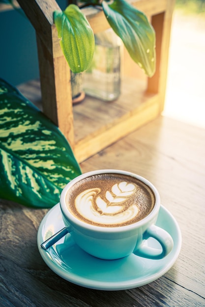 Caffè caldo latte con schiuma di latte latte art in tazza tazza sulla scrivania in legno sulla vista dall'alto come colazione in una caffetteria al concetto di lavoro aziendale cafeduring