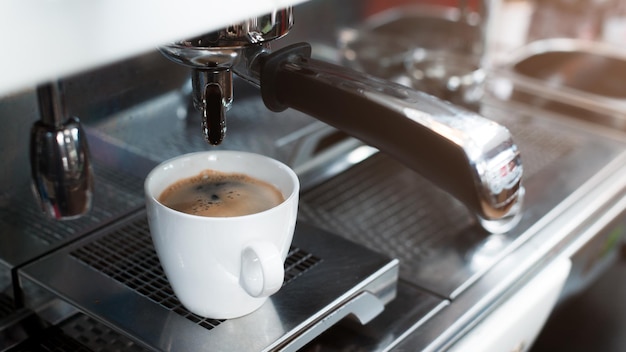 Caffè caldo su un tavolo con panna versata che mostra la consistenza