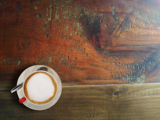 Caffè caldo sulla vecchia tabella di legno di colore marrone