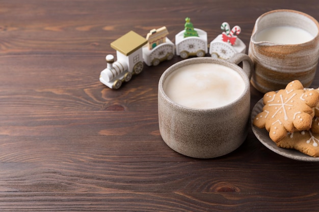 Caffè con latte e biscotti di panpepato su fondo di legno. Bevande calde invernali.