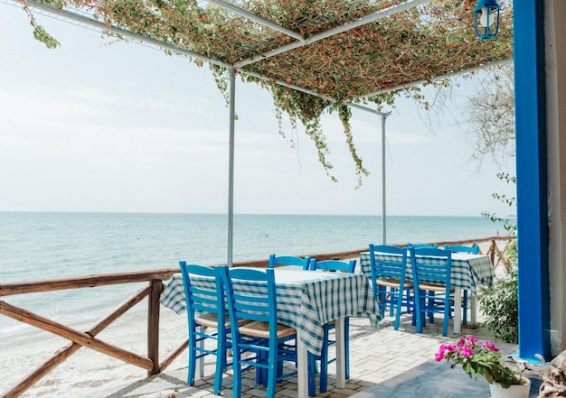 Caffè con tavoli vuoti vicino al mare. Ristorante all'aperto vicino al mare. Taverna greca.