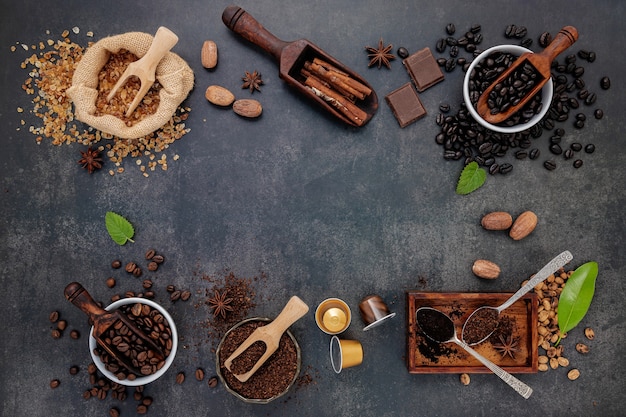 Caffè con vari chicchi di caffè tostati e ingredienti saporiti per preparare gustosi caffè su pietra scura.