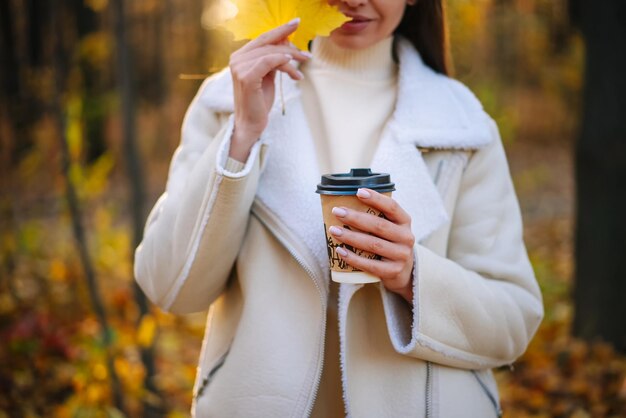 Caffè d'autunno nelle mani della donna Stile di vita stagionale che beve tè caldo
