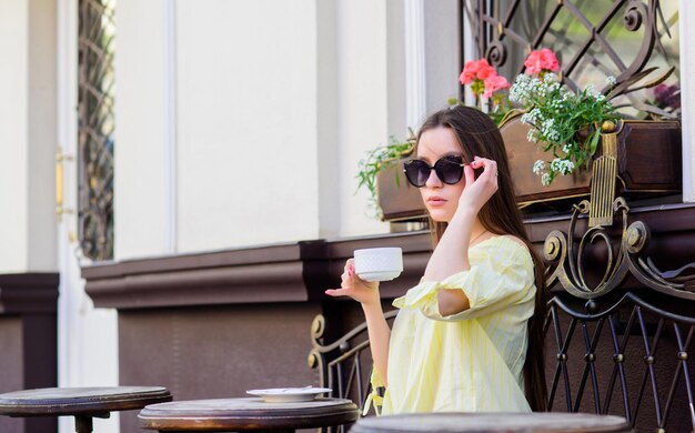 Caffè del mattino Aspettando la data ragazza rilassarsi nella caffetteria Pranzo di lavoro moda estiva Incontro nella caffetteria buongiorno Orario della colazione donna alla moda con gli occhiali bere caffè Godersi il caffè del mattino