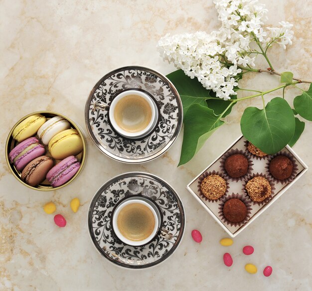 Caffè del mattino con macarons torte e un ramo di lillà