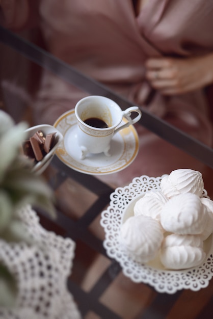 Caffè del mattino con un dessert bianco marshmallow arioso un mazzo di fiori freschi sul tavolo